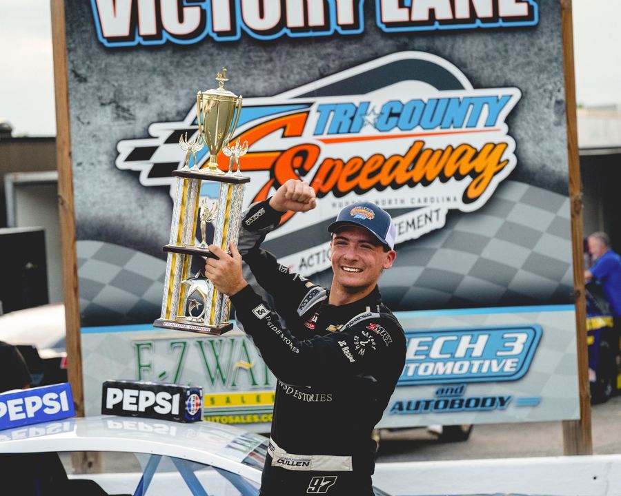 Jonah Cullen holding the trophy in victory lane at Tri-County Speedway